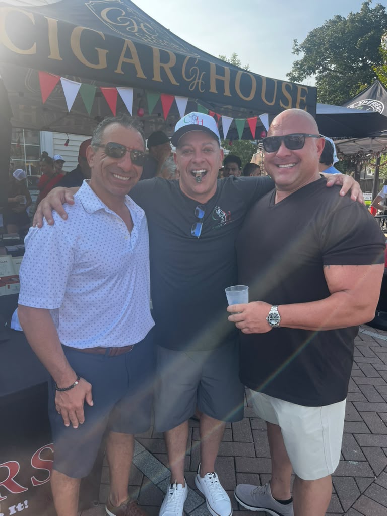 Friends with cigars in front of the Cigar House tent on Third Street at the Old Town Italian Fest in Bloomingdale