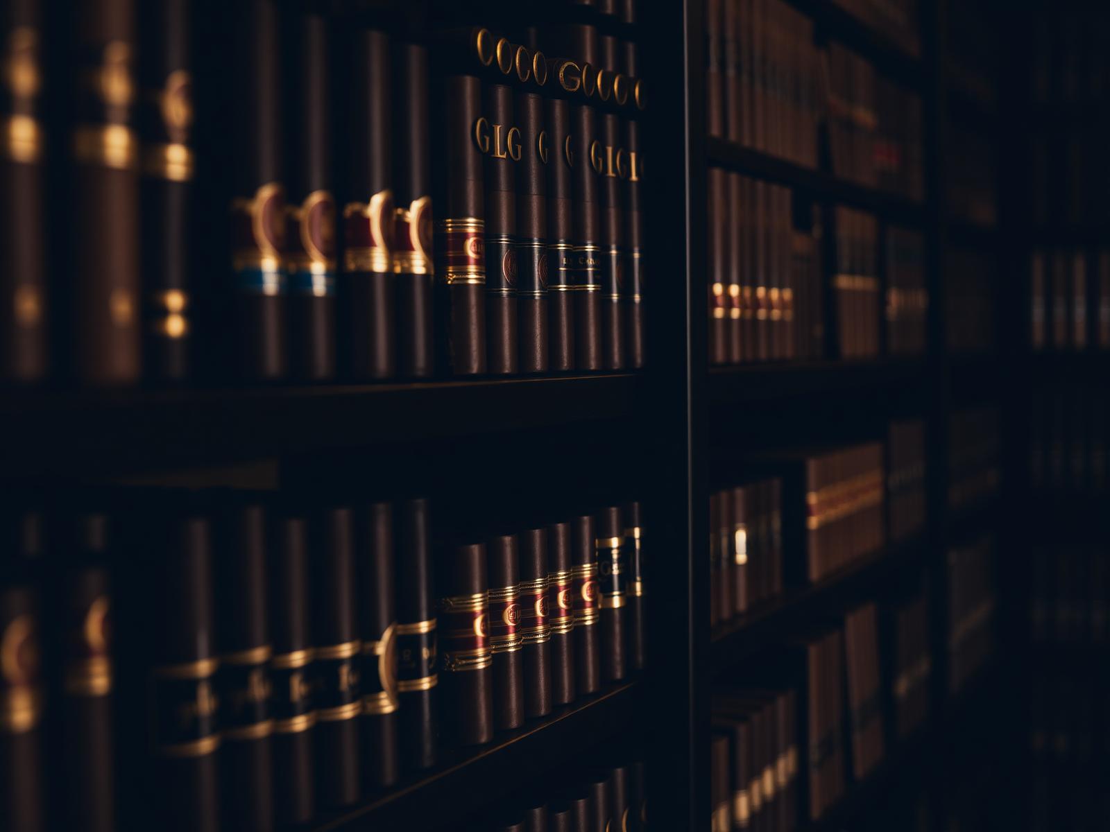 Close detail of stocked humidor shelves at Norwood Royal Cigars, rows of cigar boxes and gold-banded cigars in soft focus